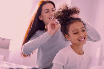 Beautiful and stylish. Happy nice girl smiling while having her ponytail done