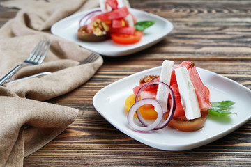 Plates with delicious watermelon salad on wooden table