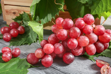 Red ripe grapes on wooden table, closeup