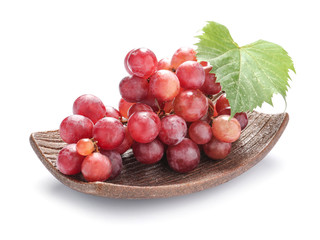 Plate with ripe grapes on white background