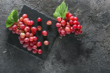Slate plate with ripe grapes on grunge table