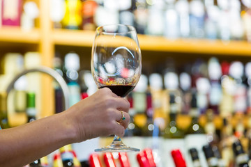 female hand holding a glass of red wine