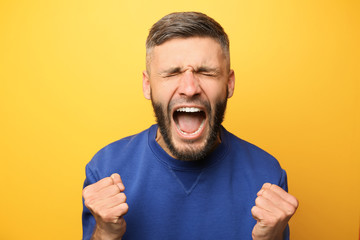 Portrait of screaming man on color background