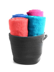 Wicker basket with bright rolled towels on white background