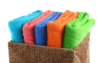 Wicker basket with folded clean towels on white background