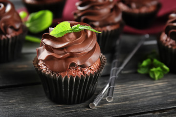 Delicious chocolate cupcake on wooden table