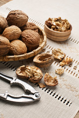 Tray with tasty walnuts and nutcracker on napkin