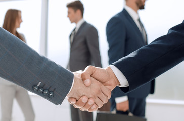 close up.handshake business partners in the background of the of