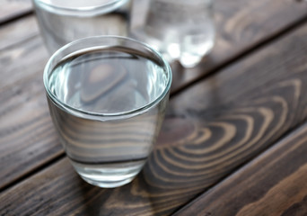 Glass of fresh water on wooden table, closeup