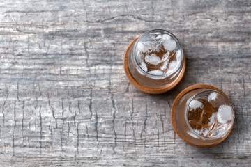Glasses of clean water with ice cubes on wooden table