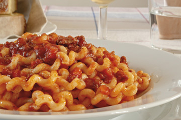 pasta lunga al ragù di carne con fette di pane fronte primo piano
