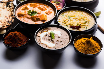 Indian Lunch / Dinner main course food in group includes Paneer Butter Masala, Dal Makhani, Palak Paneer, Roti, Rice etc, Selective focus