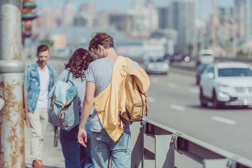Obraz premium back view of tourists walking on street while traveling together