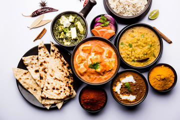 Indian Lunch / Dinner main course food in group includes Paneer Butter Masala, Dal Makhani, Palak Paneer, Roti, Rice etc, Selective focus