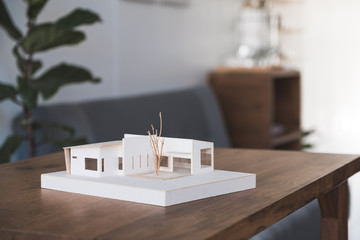 An architecture model on wooden table in office with blur nature background