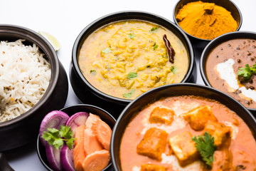 Indian Lunch / Dinner main course food in group includes Paneer Butter Masala, Dal Makhani, Palak Paneer, Roti, Rice etc, Selective focus
