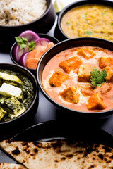 Indian Lunch / Dinner main course food in group includes Paneer Butter Masala, Dal Makhani, Palak Paneer, Roti, Rice etc, Selective focus