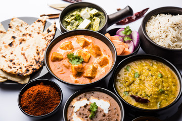 Indian Lunch / Dinner main course food in group includes Paneer Butter Masala, Dal Makhani, Palak Paneer, Roti, Rice etc, Selective focus