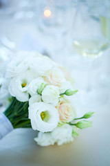 Obraz na płótnie Canvas Close up of white flower wedding bouqet o bright romantic set table in natural light