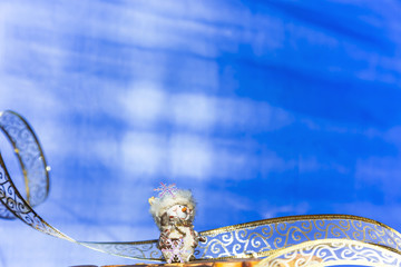 Christmas and New Year's winter festive background in blue with a garland and a figure of a souvenir snowman with a copy space for writing the text of congratulations