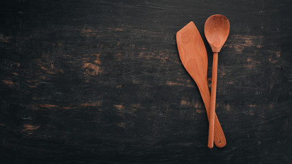 Wooden kitchen utensils. Top view. On a wooden background. Free space for your text.