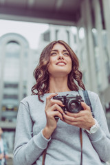 beautiful brunette tourist with photo camera in city