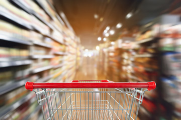 supermarket aisle blur abstract background with empty red shopping cart