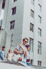 Fototapeta premium young smiling couples on tourists walking in city together