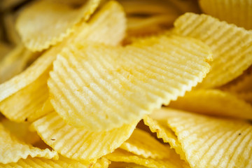 Potato chips in open snack bag close up