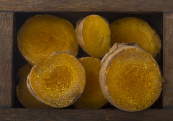 slices of turmeric in wooden box