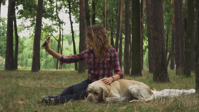 Young girl is making selfie with her Labrador