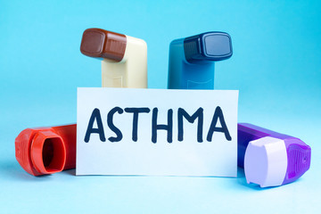 Various asthma inhalers on a blue background. Asthma and copd disease concept