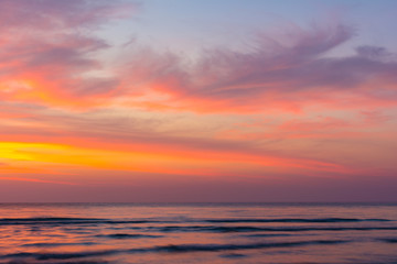 Vivid beautiful sunset and sunrise sky reflection on sea wave.