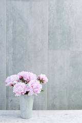 Bouquet of pink peonies on grey stone background