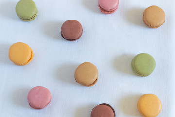 Colored macarons of different flavors on a white background