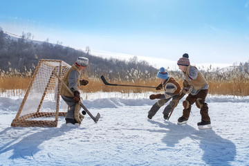 Boys play hockey on a frozen lake