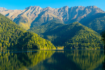 Beautiful mountain lake with green forest hills at the shore. Ritsa Lake, Abkhazia