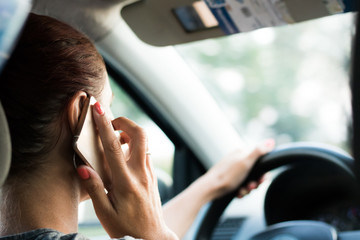 Close up of woman driving car and talking on the phone.