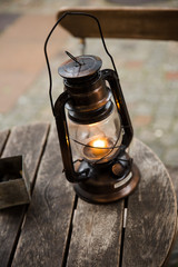 Oil lamp on a wooden round table surface