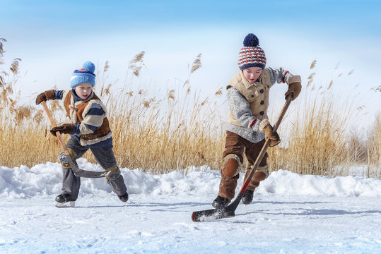 Boys play hockey on a frozen lake