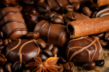 Assortment of white, dark, and milk chocolate. Chocolate with cream, nuts, almonds, hazelnuts and cinnamon with coffee beans. Sweet food and no diet concept.
