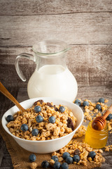 Healthy breakfast concept with oat flakes and fresh berries on rustic background. Food made of granola and muesli. Healthy banana smoothie with blackberries, honey and milk.