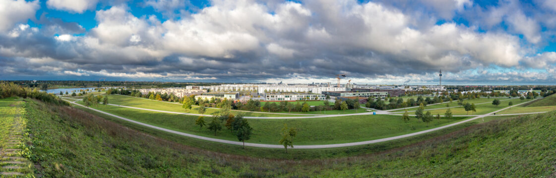 Messestadt Riem Ost in M&uuml;nchen, Panormaansicjt vom Rodelh&uuml;gel im Riemer Park bei bew&auml;lktem Himmel im Sp&auml;tsommer