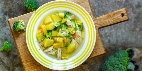 soup with broccoli, chicken and vegetables (on the table) on gray background. . top view. food background