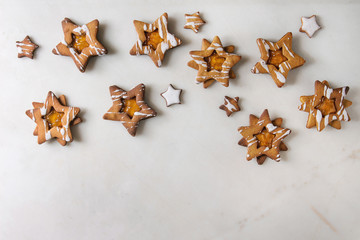 Homemade Christmas star shape sugar caramel cookies with frosting and orange citrus jam over white...