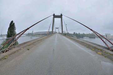 Fototapeta na wymiar View of old abandoned cable-stayed Rybalskii bridge, Kyiv,Podol, Ukraine