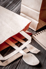 cup coffee and bread in paper bag on wooden background