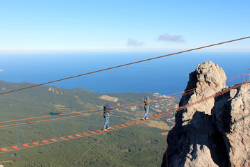 Father and son walk on the suspension bridge at an altitude of 1234 meters above sea level