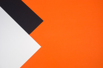 Black, orange and white color paper geometric flat lay background