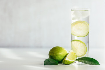 glass with water, ice and lime slices 